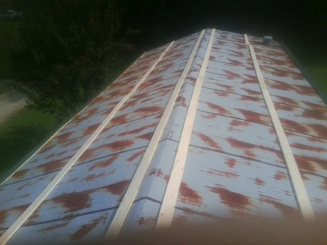 Rusted metal roof panels with new wood purlins before replacement — Storm Damage Roof Repair in Gibbon by Roofing Brothers
